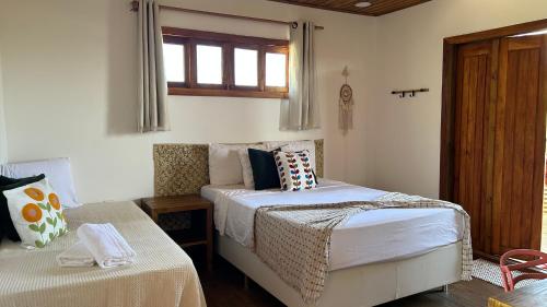 a bedroom with two beds and a window at Estação Orgânica Taipu in Marau