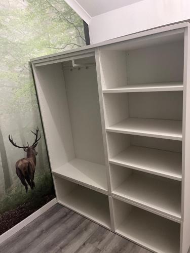 un armario con un cuadro de un ciervo en la pared en Le Refuge du Cerf, en Bouillon