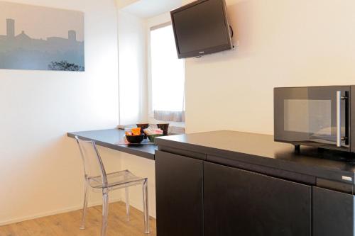 a kitchen with a desk with a microwave and a chair at b&b roccabella in Iesi