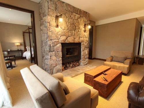 un grand salon avec une cheminée en pierre dans l'établissement Pueblo Nativo Resort Golf & Spa All Inclusive, à La Cumbre