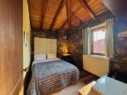 a bedroom with a bed in a room with a window at Chalet Asteras tou Vorra in Palaios Agios Athanasios