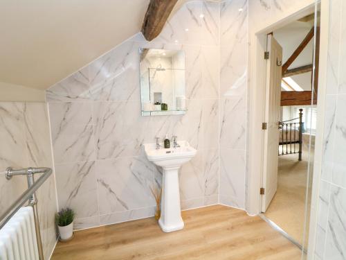 um banheiro branco com uma pia e um espelho em Brookhouse em Castleton