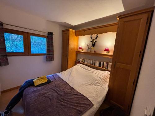 a small bedroom with a bed and a book shelf at Les Chalets du Galibier II in Valloire