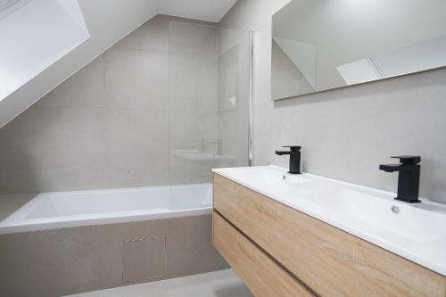 een badkamer met een wastafel en een ligbad bij Appartment Douvres 7 in Brussel