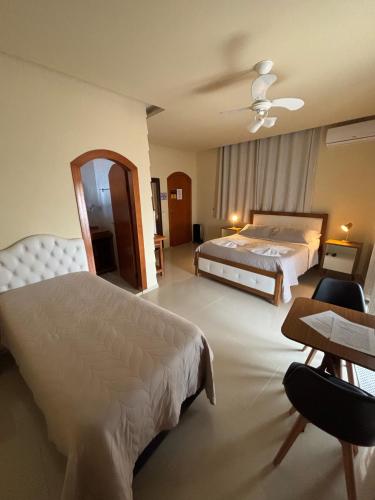 a large hotel room with two beds and a table at Espaço Nobre in Cunha