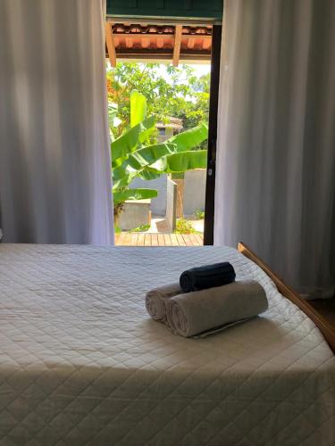a bed with two towels sitting on top of it at Aruã Suítes & Café in Penha