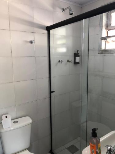 a bathroom with a shower and a toilet and a sink at Aruã Suítes & Café in Penha