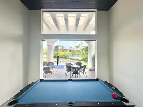 a pool table in a room with a patio at Chic 1BHK Apartment - Pool, Gym, Amenities Near Candolim Beach in Candolim