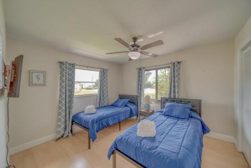 a bedroom with two beds and a ceiling fan at Villa with Pool Home and Outdoor space! in Cape Coral