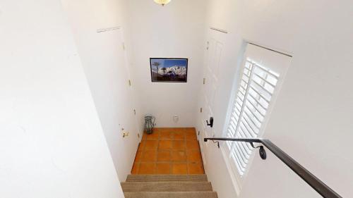 um corredor com uma escadaria com paredes brancas e uma estante em SV003 Upstairs Studio Spa Villa in LQ Resort em La Quinta