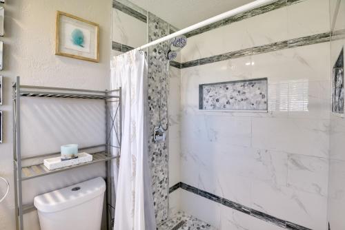 une salle de bain blanche avec douche et toilettes dans l'établissement Bright Ormond Beach Home about 14 Mi to Daytona!, à Ormond-by-the-Sea