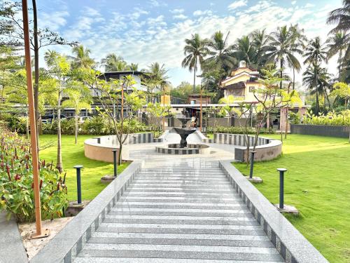 a stairway leading to a fountain in a park at Chic 1BHK Apartment - Pool, Gym, Amenities Near Candolim Beach in Candolim