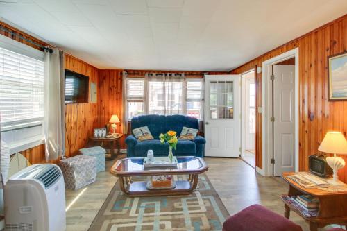 a living room with a blue couch and a table at Cozy Hampton Cottage - Walk to Beaches and Marina! in Hampton