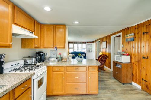 a kitchen with wooden cabinets and a white stove top oven at Cozy Hampton Cottage - Walk to Beaches and Marina! in Hampton