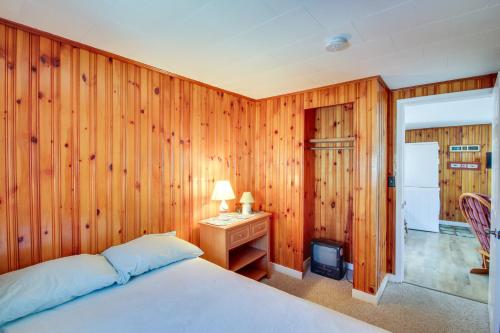 une chambre avec un lit et un bureau avec une lampe dans l'établissement Cozy Hampton Cottage - Walk to Beaches and Marina!, à Hampton Beach