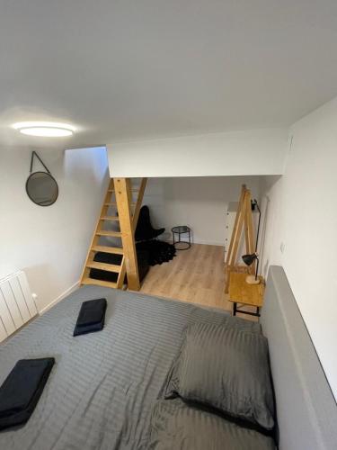 een slaapkamer met een bed en een trap op de achtergrond bij Le souplex in Nuillé-sur-Vicoin
