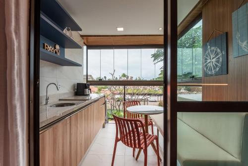 a kitchen with a table and chairs and a window at Prédio em Barra Grande - Maragogi in Maragogi