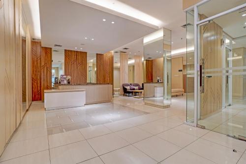 een kantoorlobby met een receptie en stoelen bij OYO 94837 Apartment Ekki Tower in Tjikuda Dua