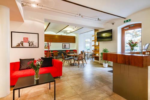 a living room with a red couch and a table at B&B Villa Hotel in Mariánské Lázně