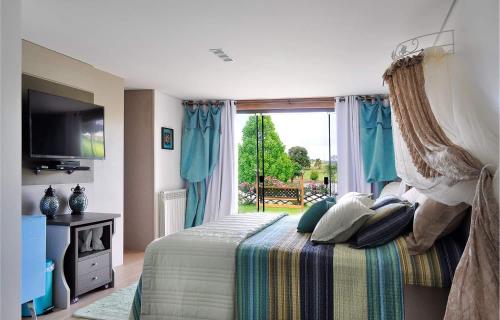 a bedroom with a bed and a large window at A Cabanha in Caçador