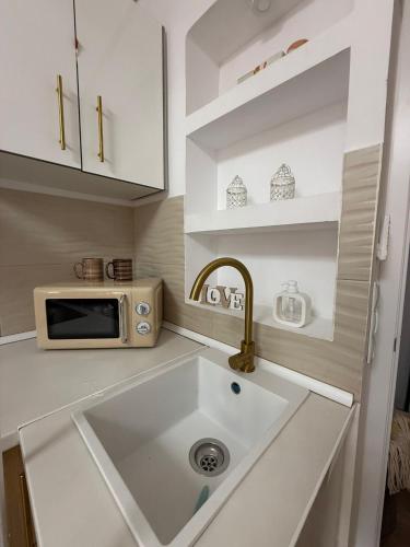 a kitchen with a sink and a microwave at Duplex Ático con terraza y BBQ in Puerto de Sagunto