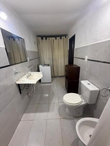 a white bathroom with a toilet and a sink at CASA Barrio Parque Mar in Miramar
