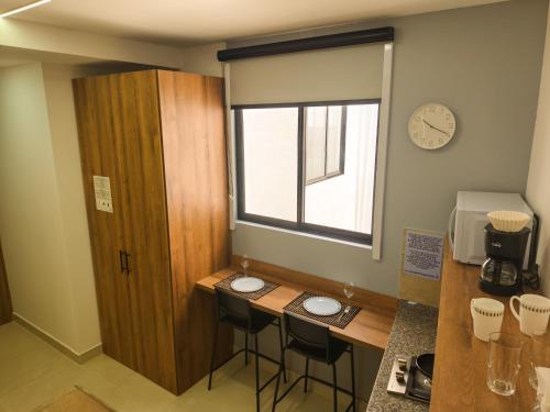 a kitchen with a table and two stools in a room at Mi Fortaleza Cali, Valle del Cauca Santa Isabel Cerca a IMBANACO in Cali