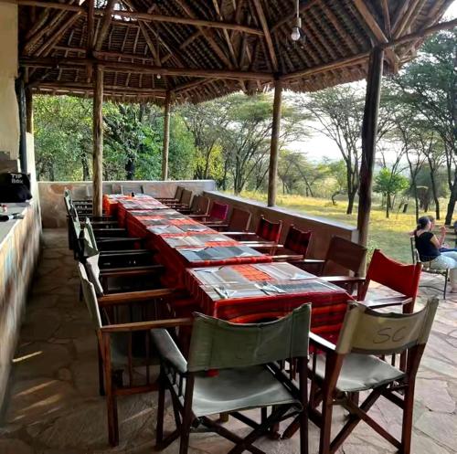 una mesa larga con sillas y una mesa larga en Enchoro mara, en Sekenani