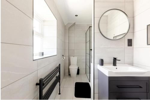 a white bathroom with a sink and a mirror at Entire house, close to central Bristol in Bristol