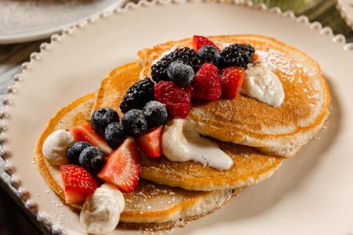 Un plato de panqueques con fruta encima. en The Elmore Hotel, DFW Southlake, a Tribute Portfolio Hotel, en Southlake