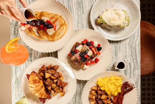 una mesa con platos de comida para el desayuno. en The Elmore Hotel, DFW Southlake, a Tribute Portfolio Hotel, en Southlake