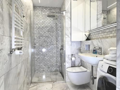 a bathroom with a sink and a toilet and a shower at White Marble in Black Pearl Chic City Centre in Szczecin