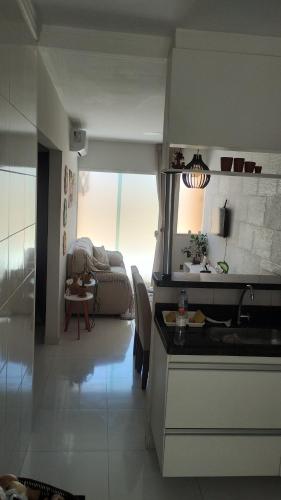 eine Küche mit Spüle und ein Wohnzimmer in der Unterkunft Condomínio Maria Clara II in Lauro de Freitas