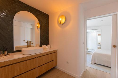 a bathroom with a sink and a mirror at Casa das Costinhas in Loureda