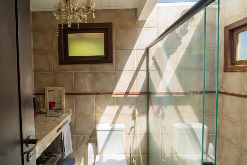 a bathroom with two toilets and a glass shower at Casas Divino in Cayru