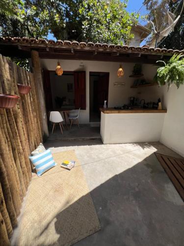 eine Terrasse mit einem Tisch und einem Haus in der Unterkunft chalé coração da vila Caraíva in Porto Seguro