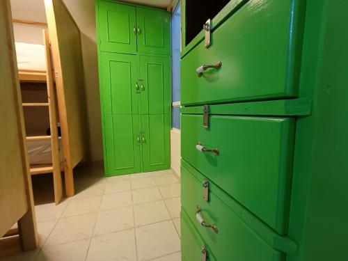 a green kitchen with two green doors in a room at Jardin 85 Boutique Hostel in Morelia