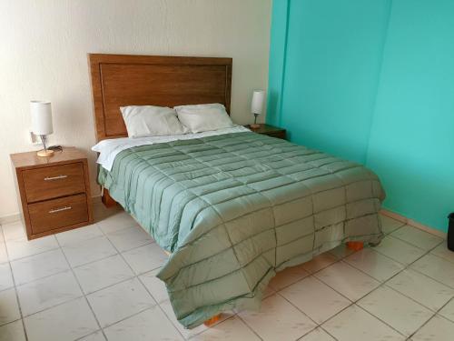 a bedroom with a large bed and two night stands at Jardin 85 Boutique Hostel in Morelia