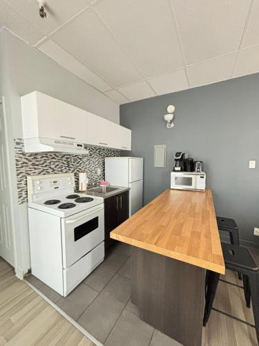 a kitchen with a white stove and a wooden counter top at Urban Loft, St-Joseph St in Quebec City
