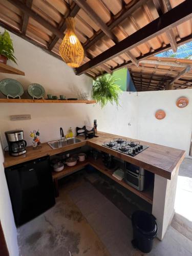 eine Küche mit einer Theke mit einem Herd und einer Spüle in der Unterkunft chalé coração da vila Caraíva in Porto Seguro