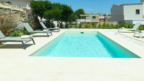 a swimming pool with two lounge chairs and a swimming pool at Dimora Zenieri – Terrazze & Piscina in Casarano