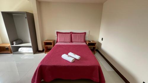 a bedroom with a bed with two towels on it at Caminho de Itacoatiara in Niterói