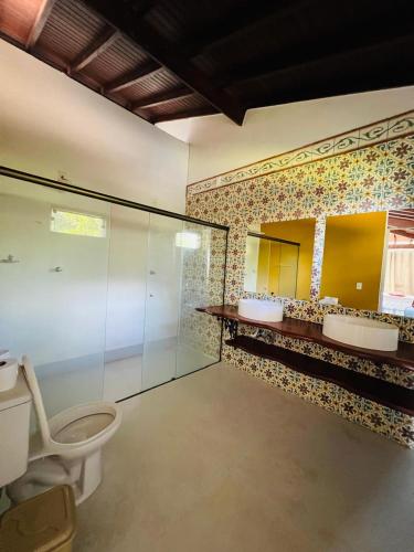 a bathroom with three sinks and a toilet in it at Rancho Toca dos Coelhos in Três Pontas