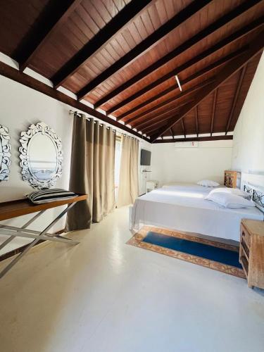 a bedroom with a large bed and a wooden ceiling at Rancho Toca dos Coelhos in Três Pontas
