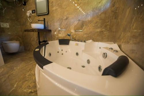 a large white bath tub in a bathroom at Etno Park Avlija Glušci 