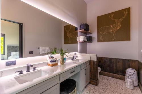 a bathroom with two sinks and a mirror at Bucks and Bunnies at Eagles Nest in Elk Park