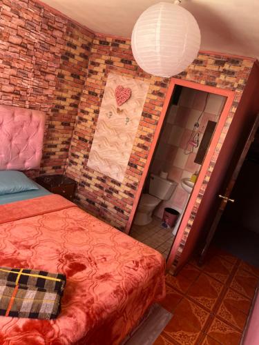 a bedroom with a bed and a brick wall at Hotel del valle in Melipilla