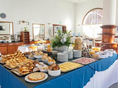 een tafel gevuld met verschillende soorten brood en gebak bij Hotel Reviens in Pinamar