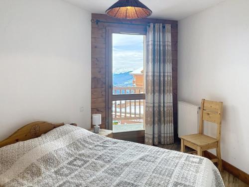 Un dormitorio con una cama y una ventana grande. en Appartement lumineux au centre avec balcon, 4 pers - FR-1-275-146, en La Rosière