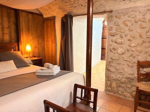 a bedroom with a bed and a stone wall at LEscala - Ventalló. Cosy WiFi Rooftop terrace in Ventalló